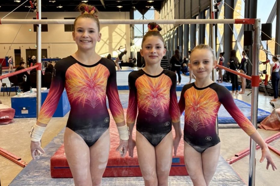 Three young athletes preparing for uneven bars at Pegasus Gymnastics.