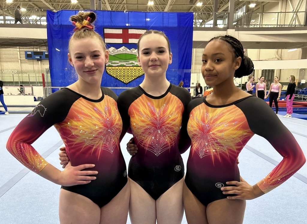Three Pegasus gymnasts smiling after a gymnastics competition.