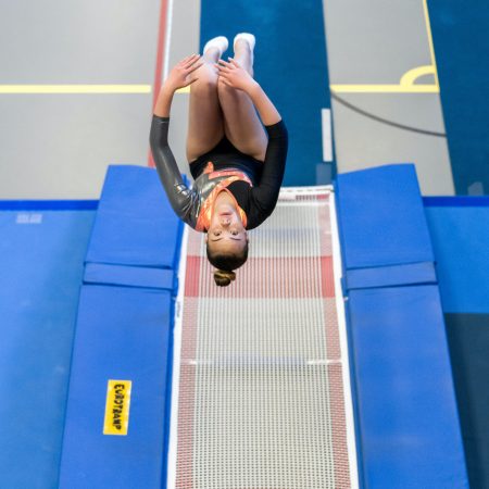 female gymnast doing back flip on trampoline